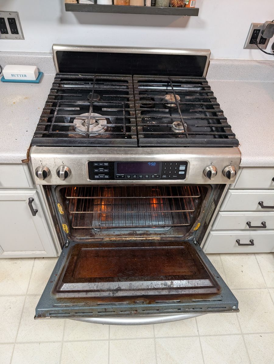Oven with dirty door and racks before cleaning